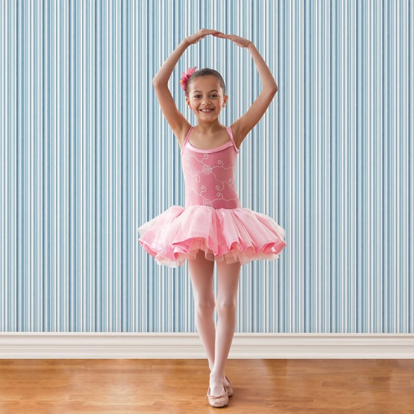Pink girls ballet tutu dress with sparkly bodice and fluffy tulle skirt, thin straps; ballet pose on wooden floor.