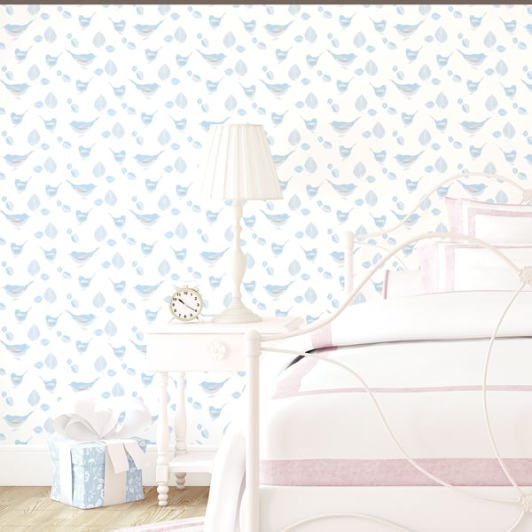Pastel blue bird-pattern wallpaper in a white bedroom with a white bedside table, lamp, clock, gift box and pink-trimmed bedding.