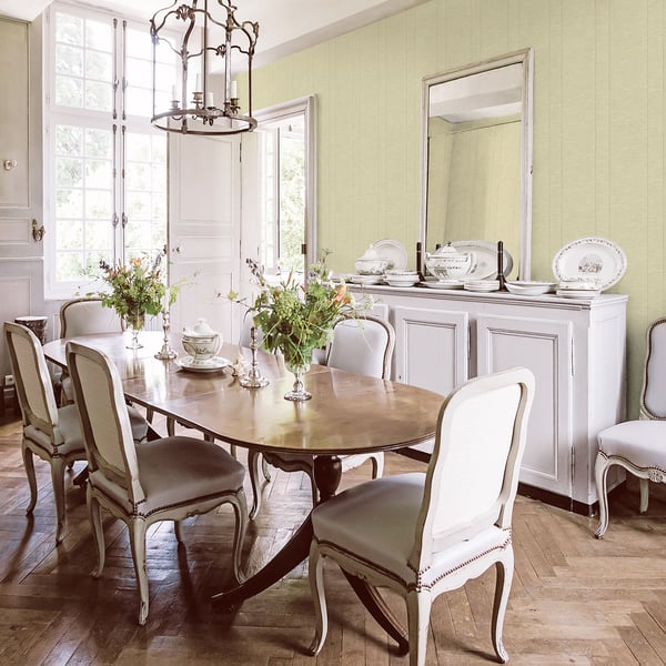 Green striped wallpaper on the walls of a dining room scene; cream upholstered dining chairs surround a wooden oval table.