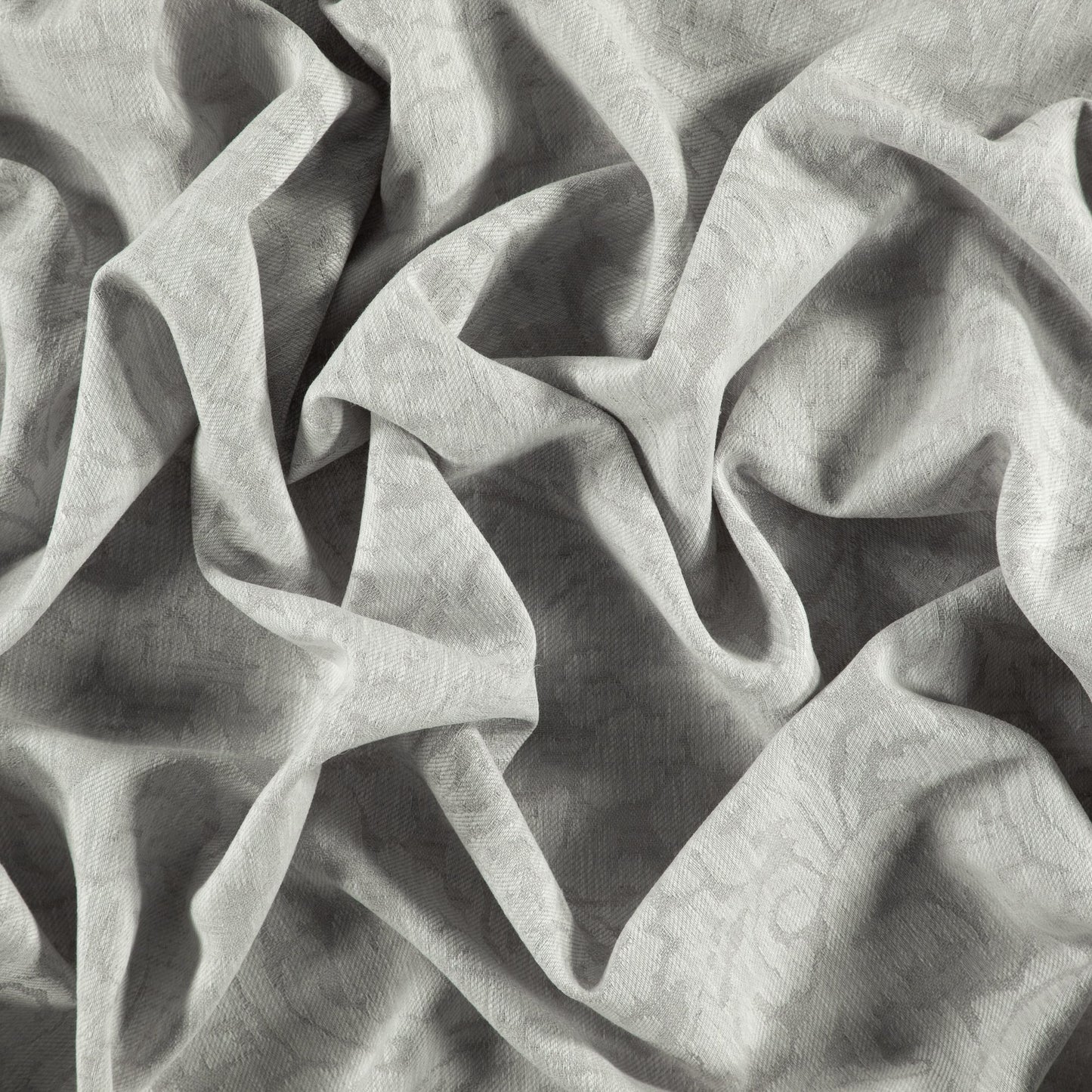 Light gray textured damask jacquard fabric with subtle pattern and soft draped folds.