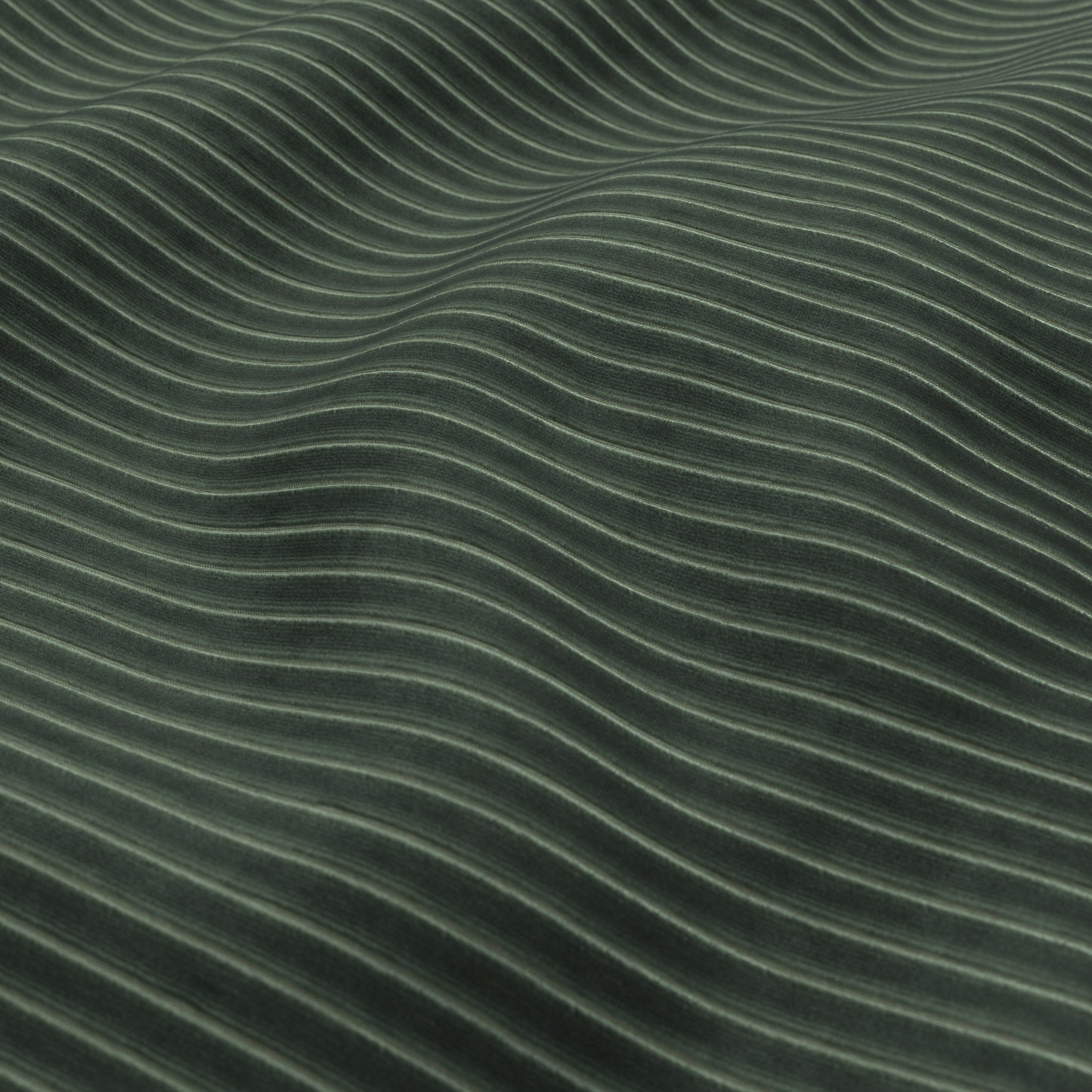 Close-up of hunter green velvet corduroy fabric texture with soft, wavy ridges.
