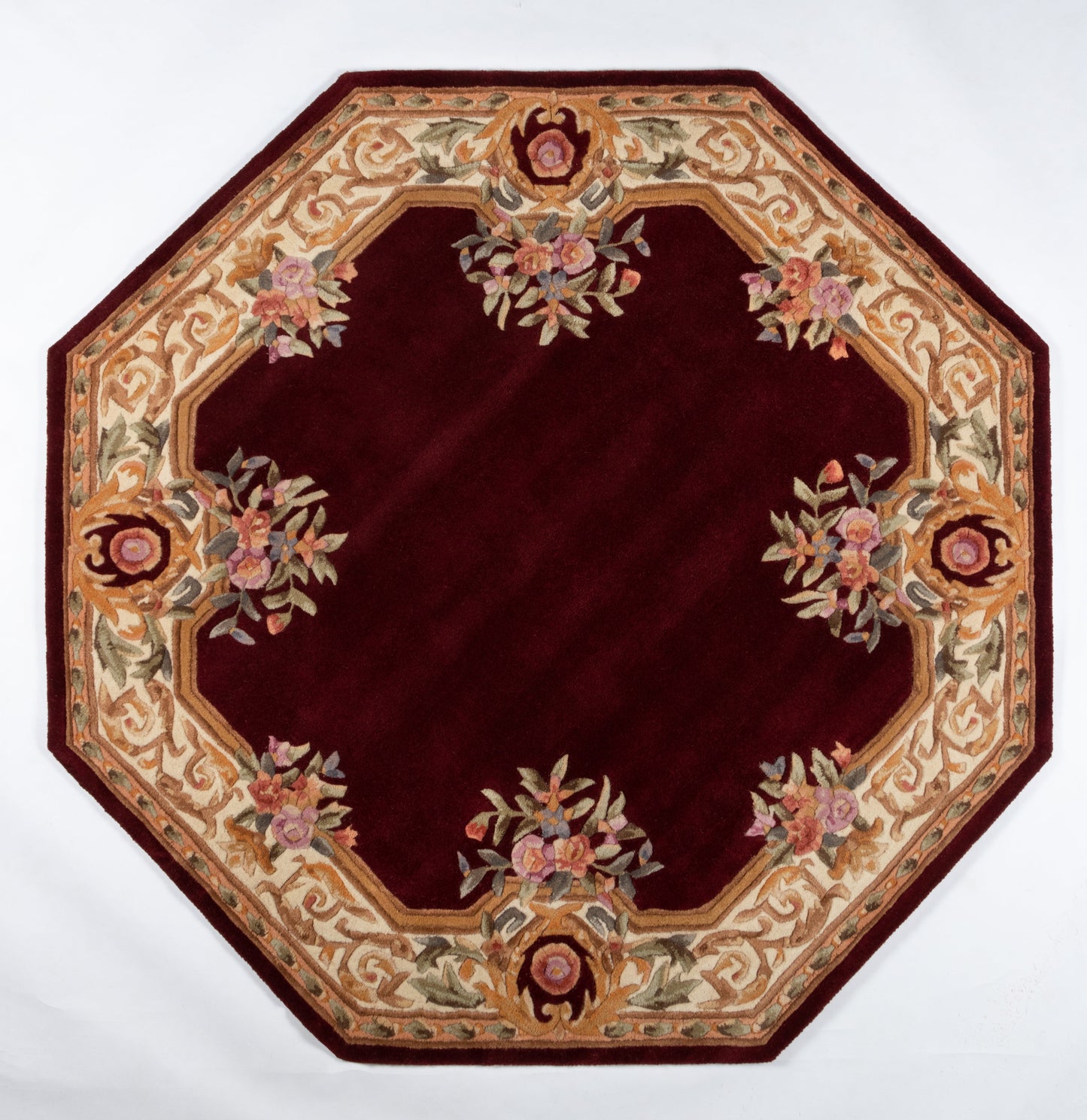 Rectangular rug with burgundy center and cream-gold scrolling border featuring pink floral bouquets.