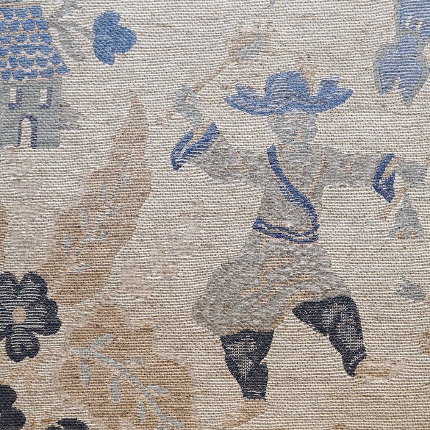 Woven tapestry fabric in beige and blue, dancing figure in blue hat, flowing robe, surrounded by floral motifs.