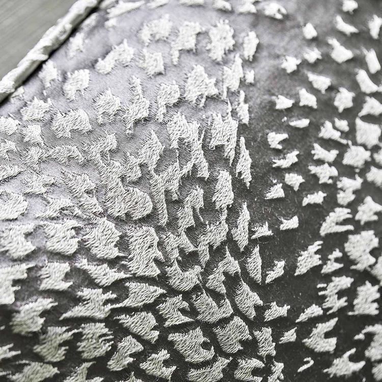 Dark grey textured fabric with metallic silver raised tufted dots in a harlequin pattern; ideal for cushions.