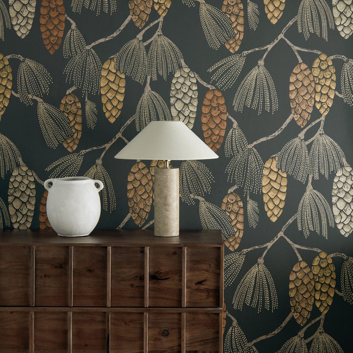 Harlequin Epitome luxury wallpaper in copper, gold, and sepia tones. Stylized pine cones, fir needles, and floral motifs on dark chalk-textured background. Roll width 20.5″ (~1.7 ft), roll length 11 yd (~33 ft), half-drop repeat. Perfect for feature walls and boutique interiors.