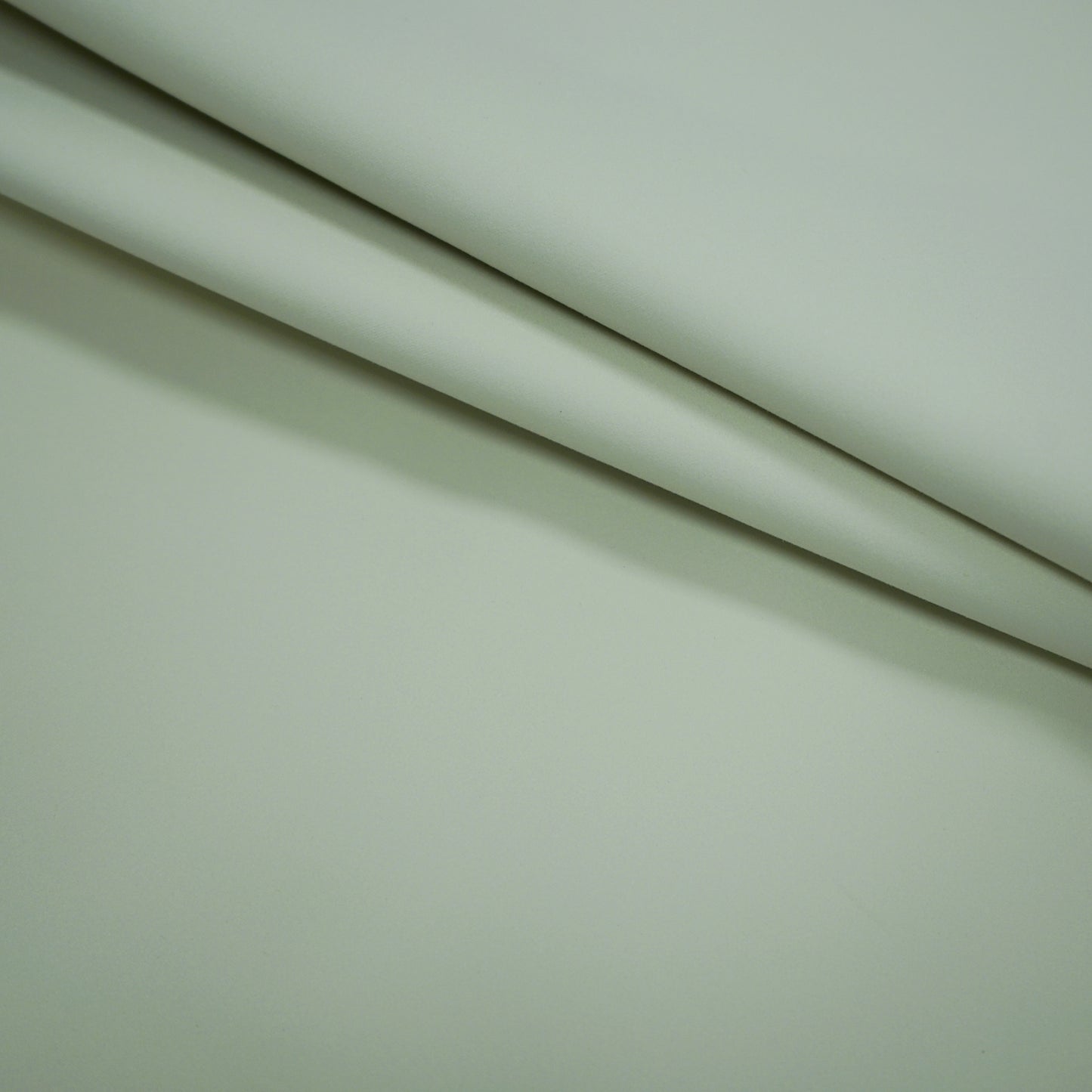 Creme beige fabric folds with a smooth matte finish and soft drape; blackout lining fabric.