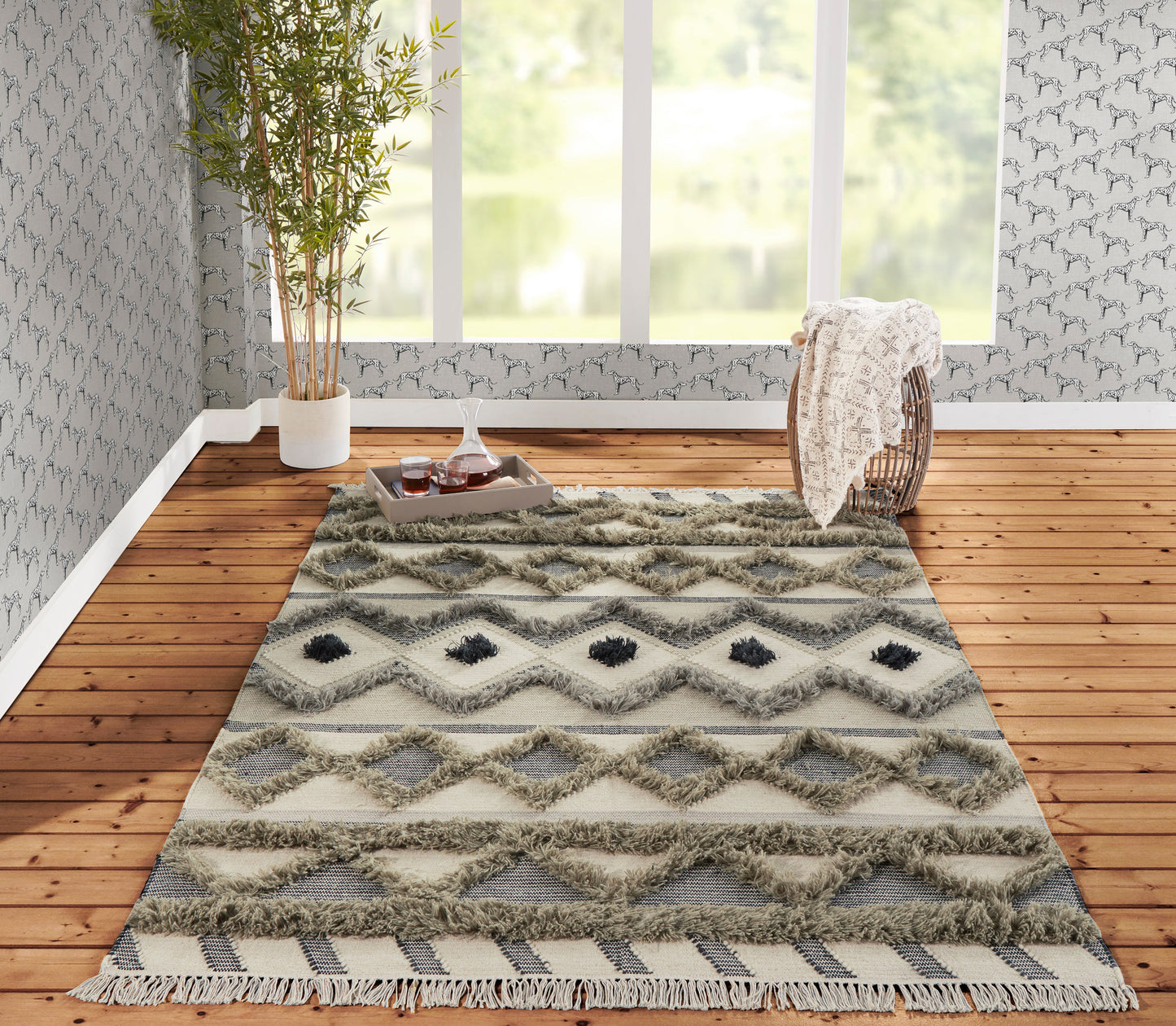 Boho shag rug with ivory and gray diamond patterns, fringed edges, laid on warm wood flooring in bright modern space