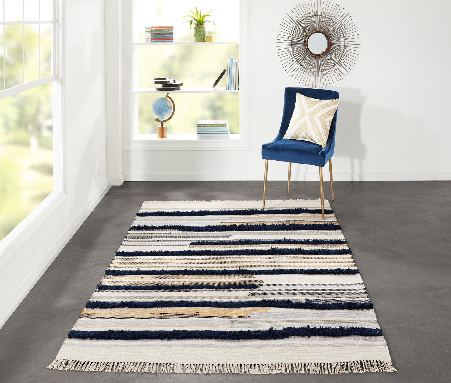Navy-cream striped area rug, 5' x 7', on a bright modern living room floor with a sunburst mirror visible in the background.
