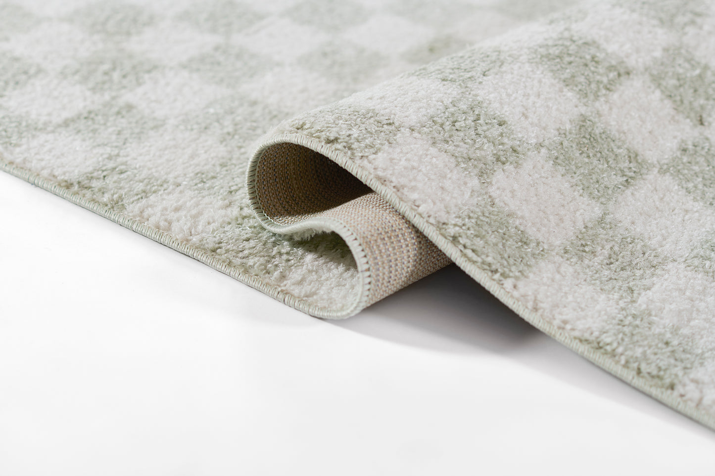 Soft grey-green geometric checkered rug with plush pile and exposed underside.