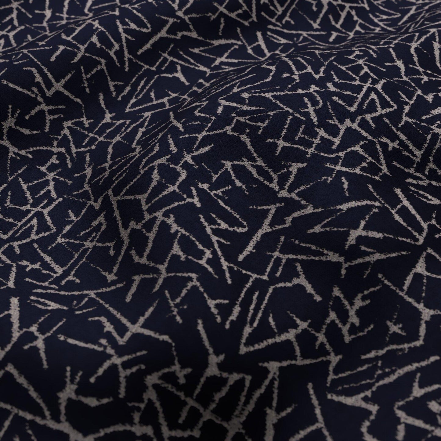 Navy blue fabric with silver scattered zigzag lines; abstract textile for upholstery or throw.