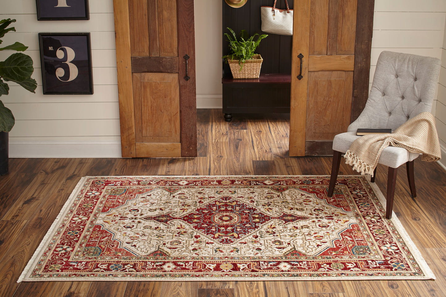 Rectangular oriental-style runner in red, ivory and teal with a floral medallion and ornate border on a wood floor.