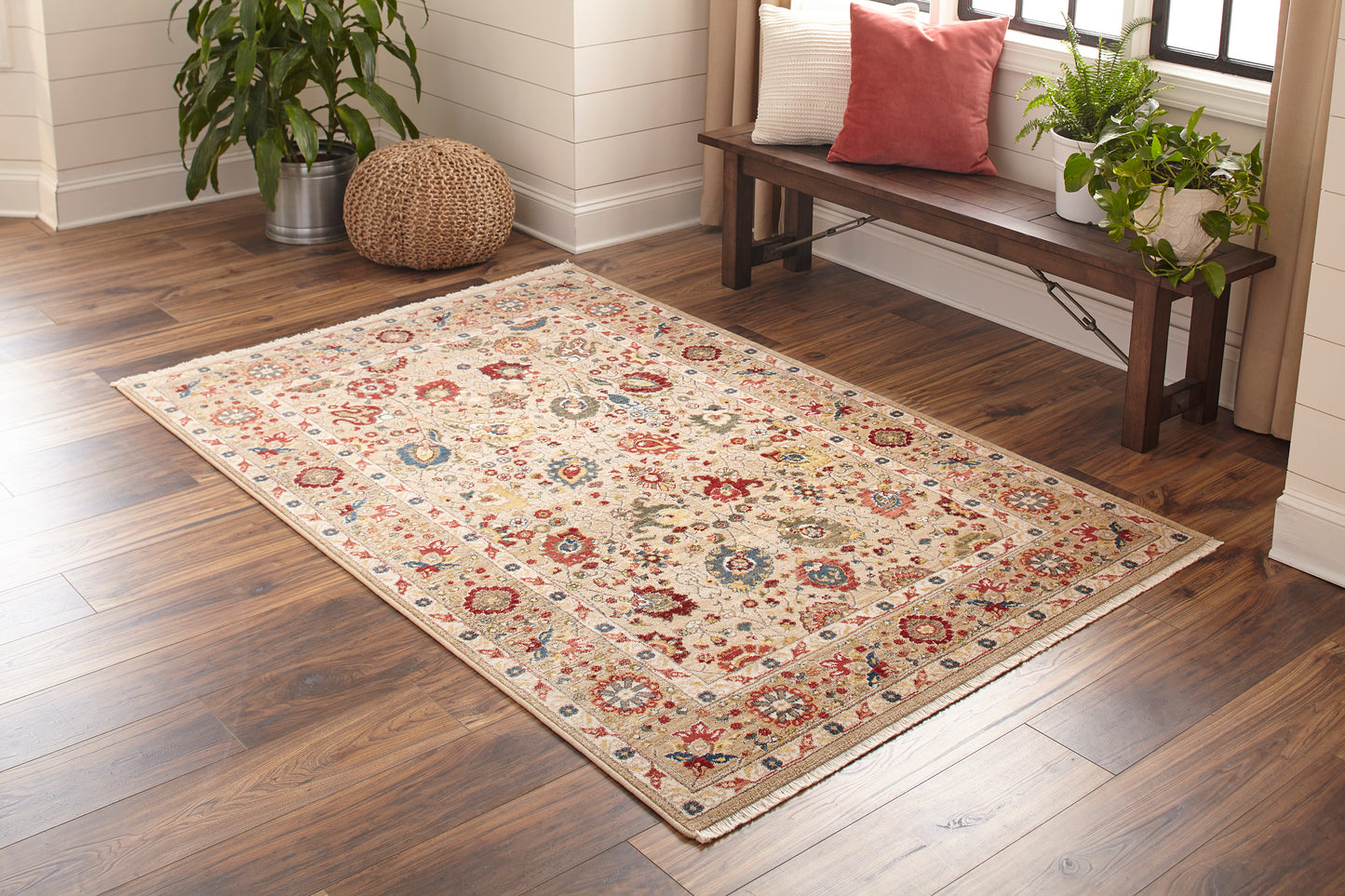 Ivory oriental runner with multicolor medallions on a dark hardwood floor in a cozy living room.