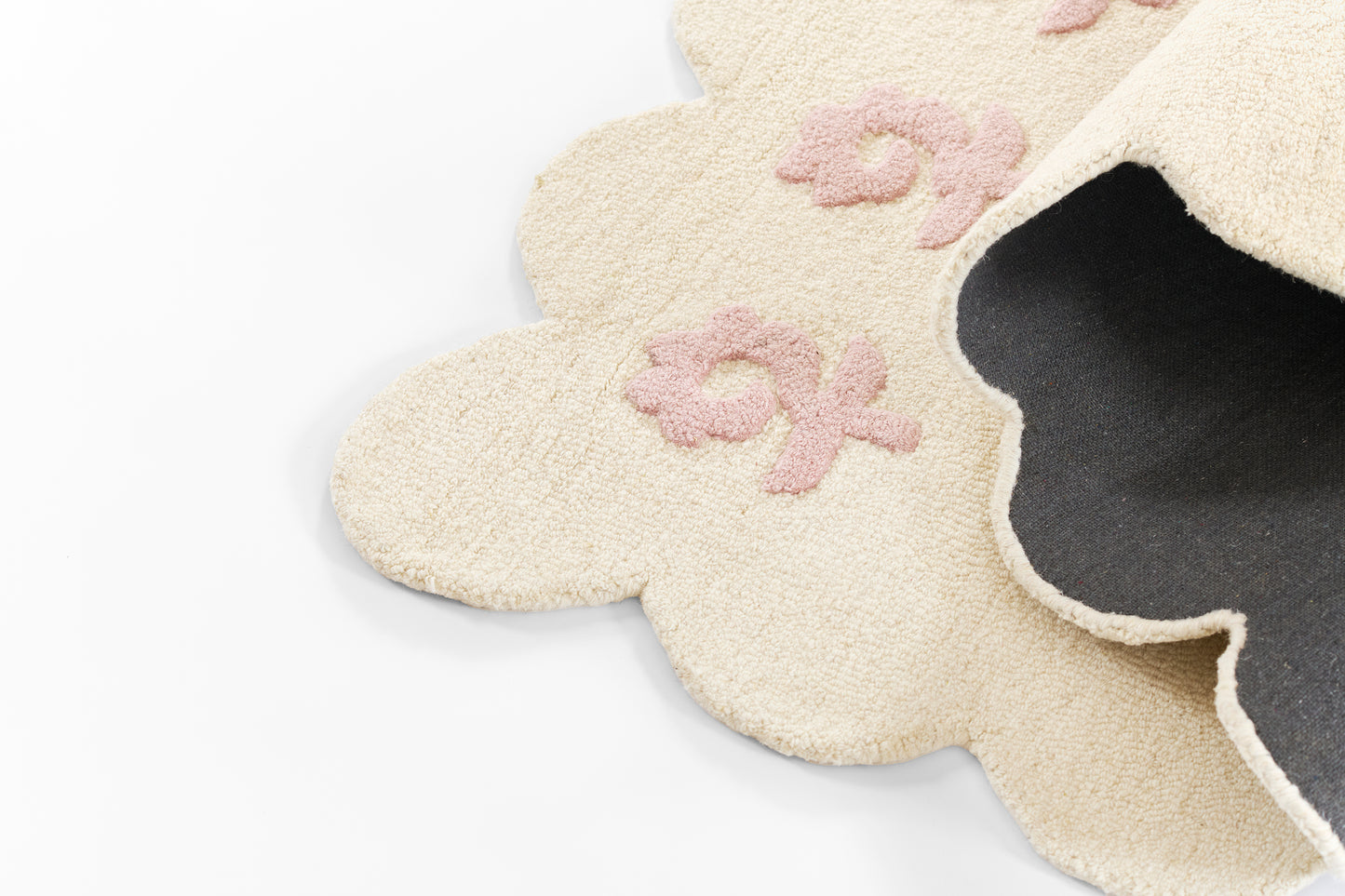 Cream plush cloud-shaped rug with pink floral embroidery; scalloped edges, soft kid-friendly rug.
