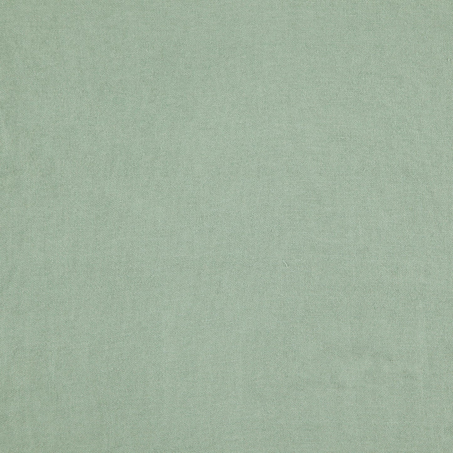 Close-up of light sage green linen fabric with subtle woven texture.