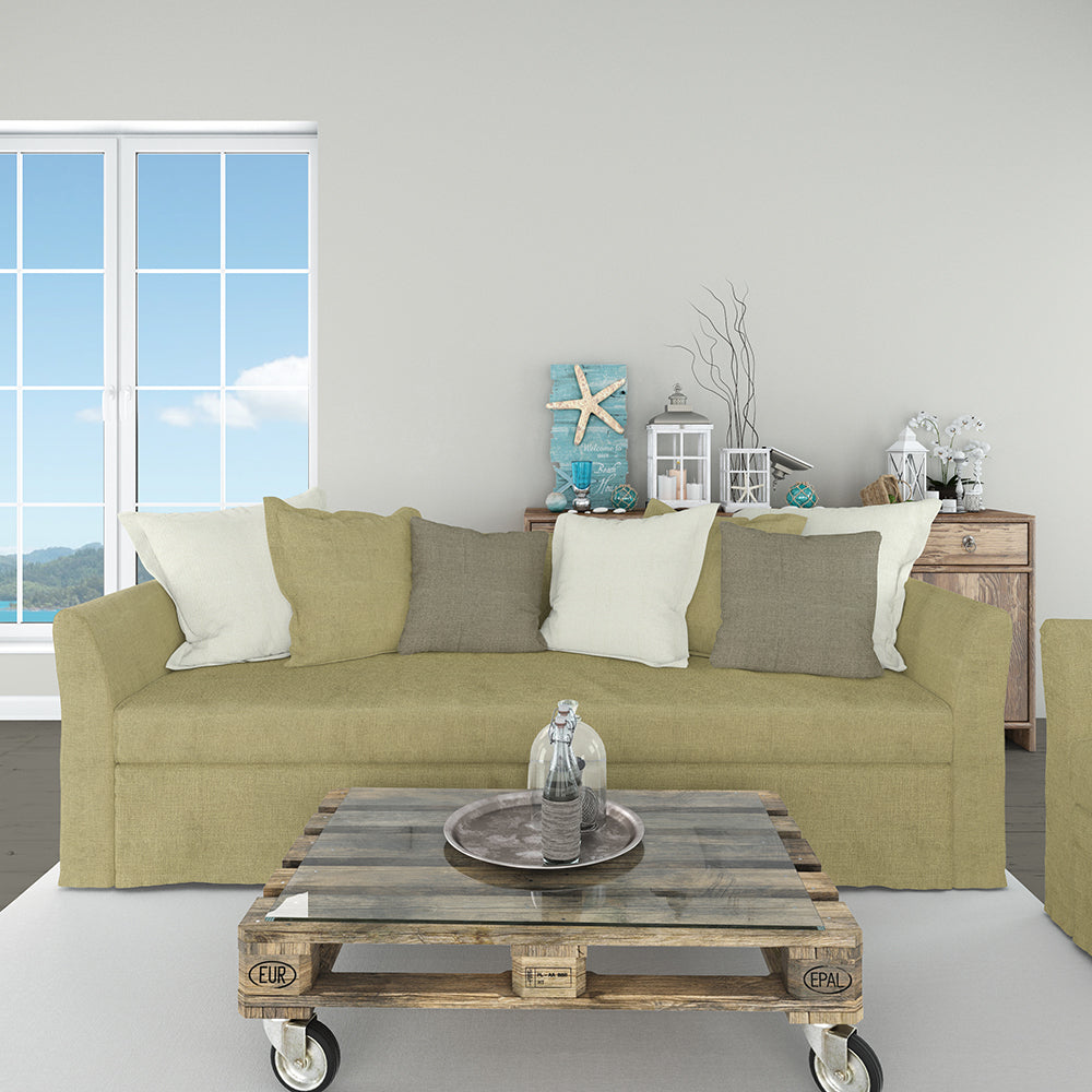 Solid lichen fabric upholstery in a coastal-style living room scene: olive sofa with light pillows, rustic wheeled pallet coffee table, seaside decor & window view.