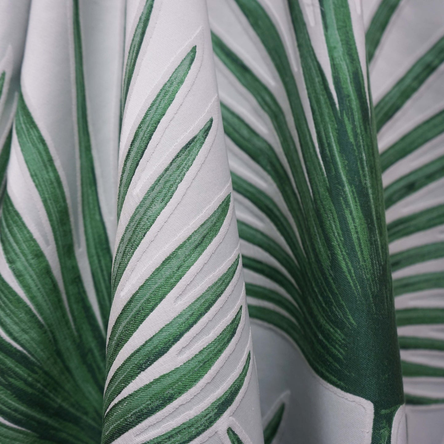 Cream fabric with green palm leaf pattern, tropical botanical print, draped fabric for curtains.