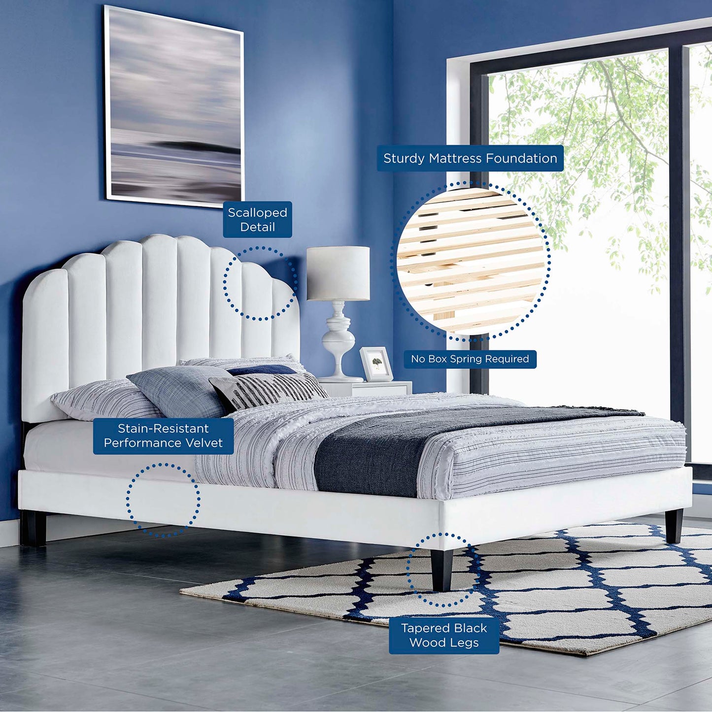 White velvet upholstered platform bed with a scalloped headboard, black tapered wood legs, no box spring required, blue-gray bedding.