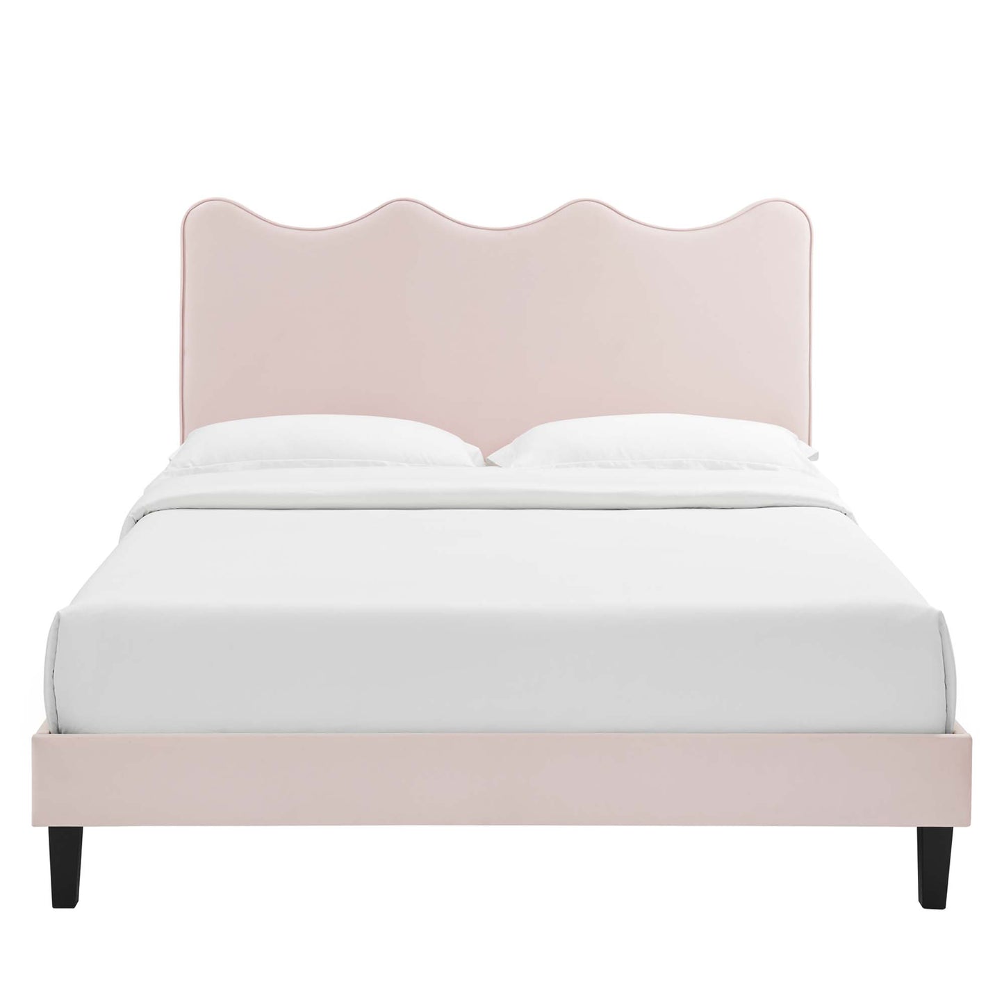 Soft pink upholstered platform bed with a scalloped, wavy headboard, white bedding, and black tapered legs.