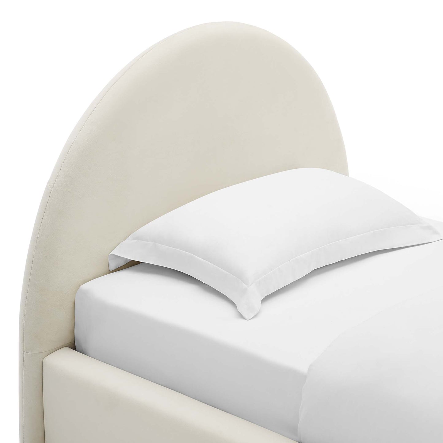 Cream curved upholstered headboard bed with white sheets and pillow