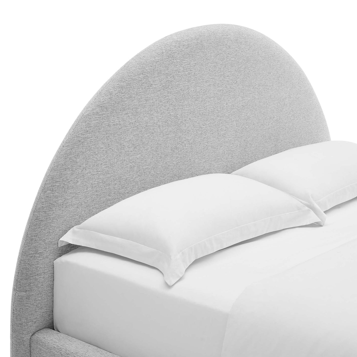 Light gray curved fabric headboard with white sheets and pillows on a bed