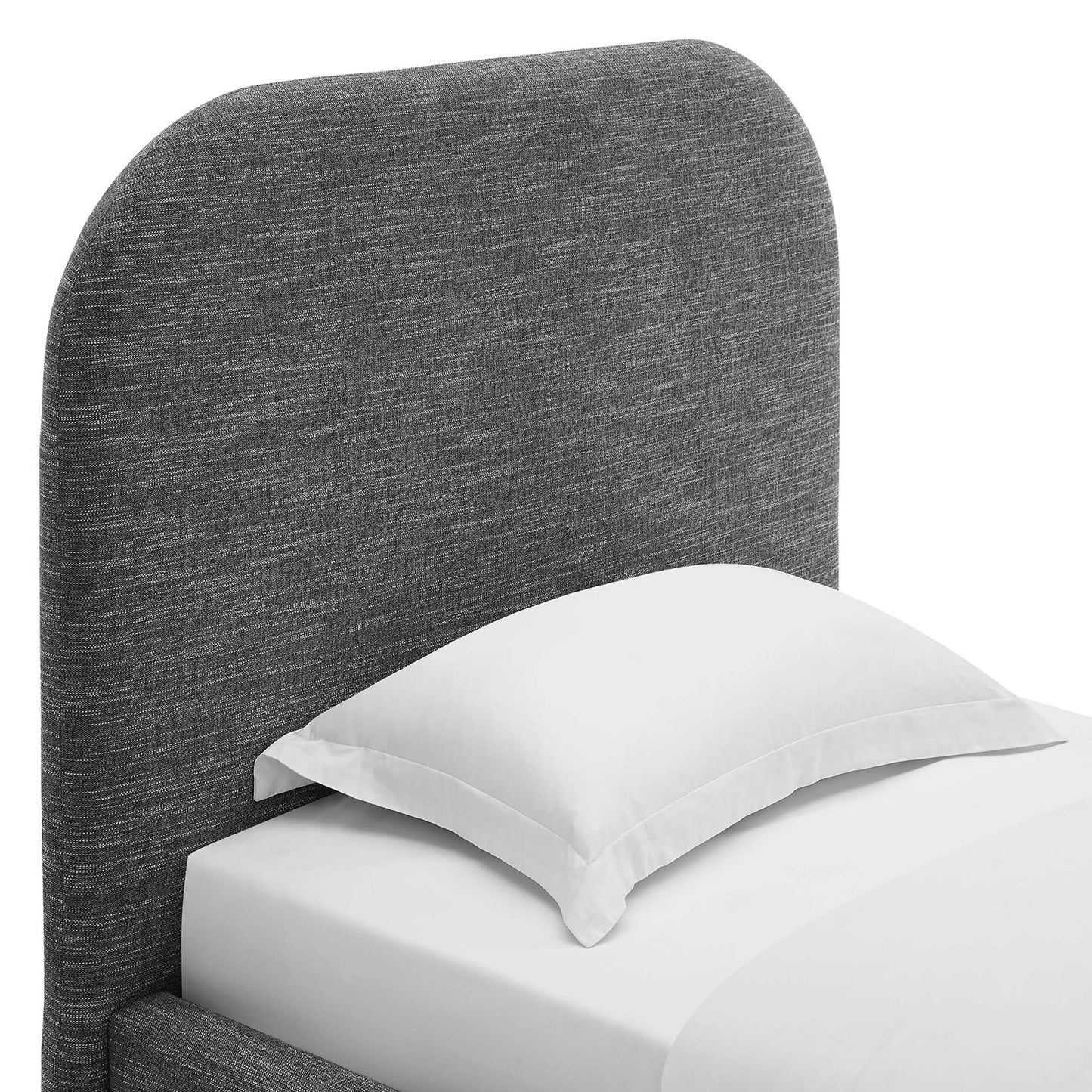 Dark gray fabric upholstered curved headboard on a modern twin platform bed with white bedding