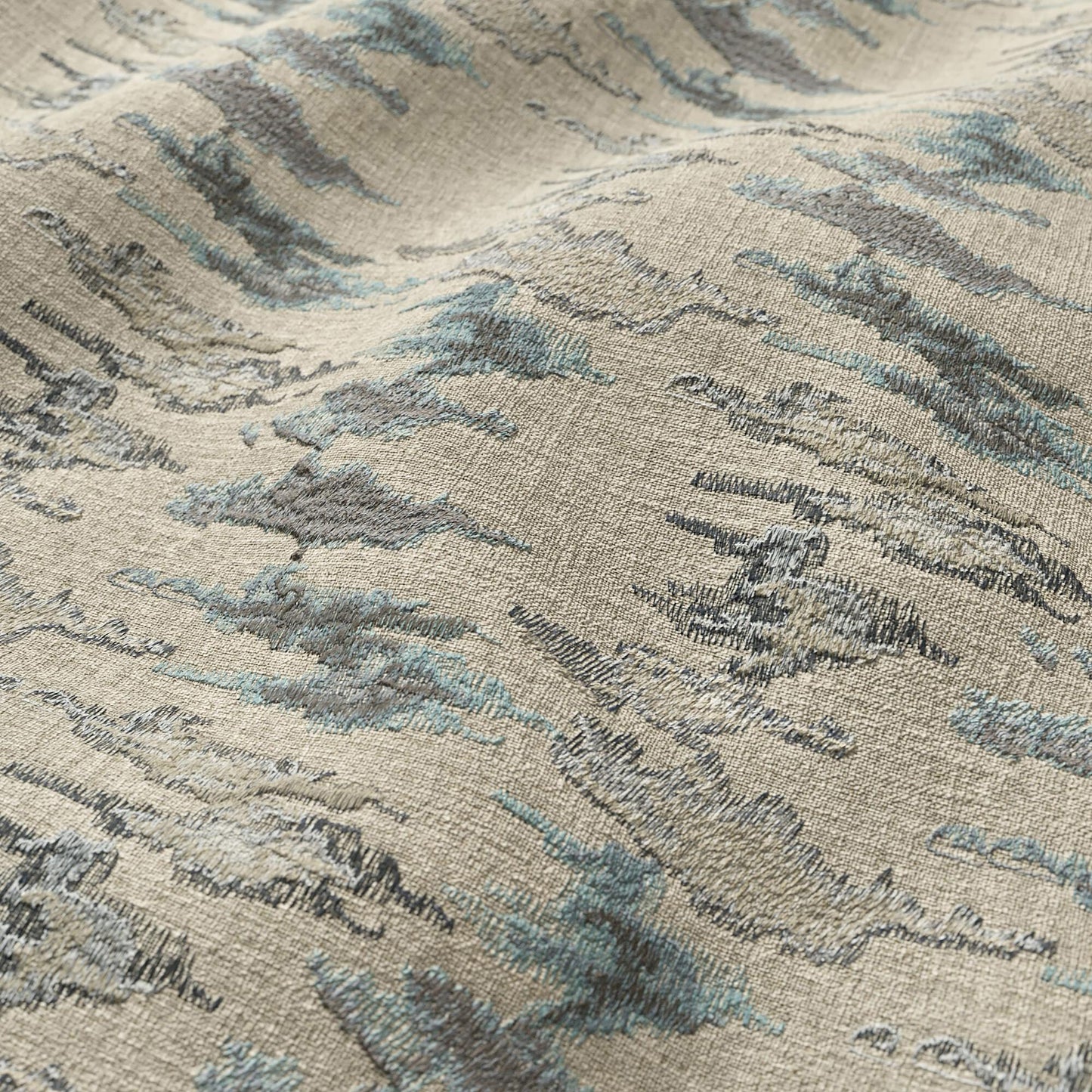 Beige woven fabric with abstract blue-gray Ikat pattern; modern, textured, suitable for upholstery and home decor.
