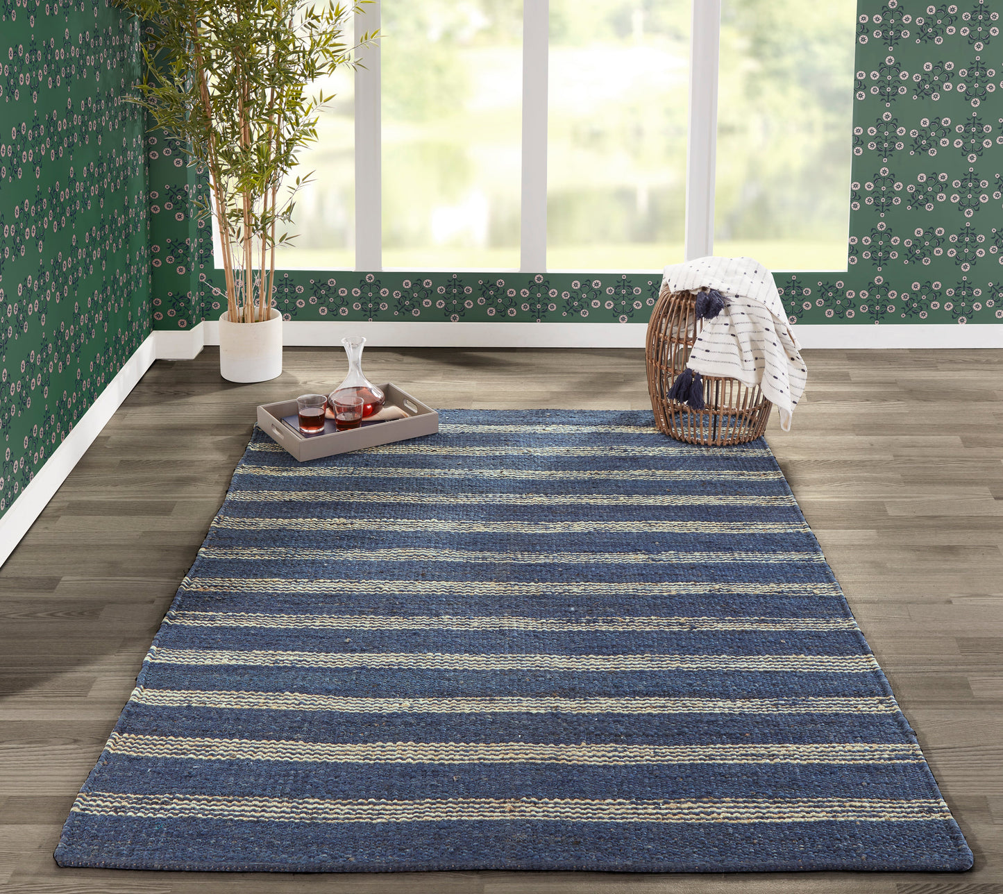Textured woven navy blue rug with beige stripes, rectangular on a wood floor in a cozy living area.