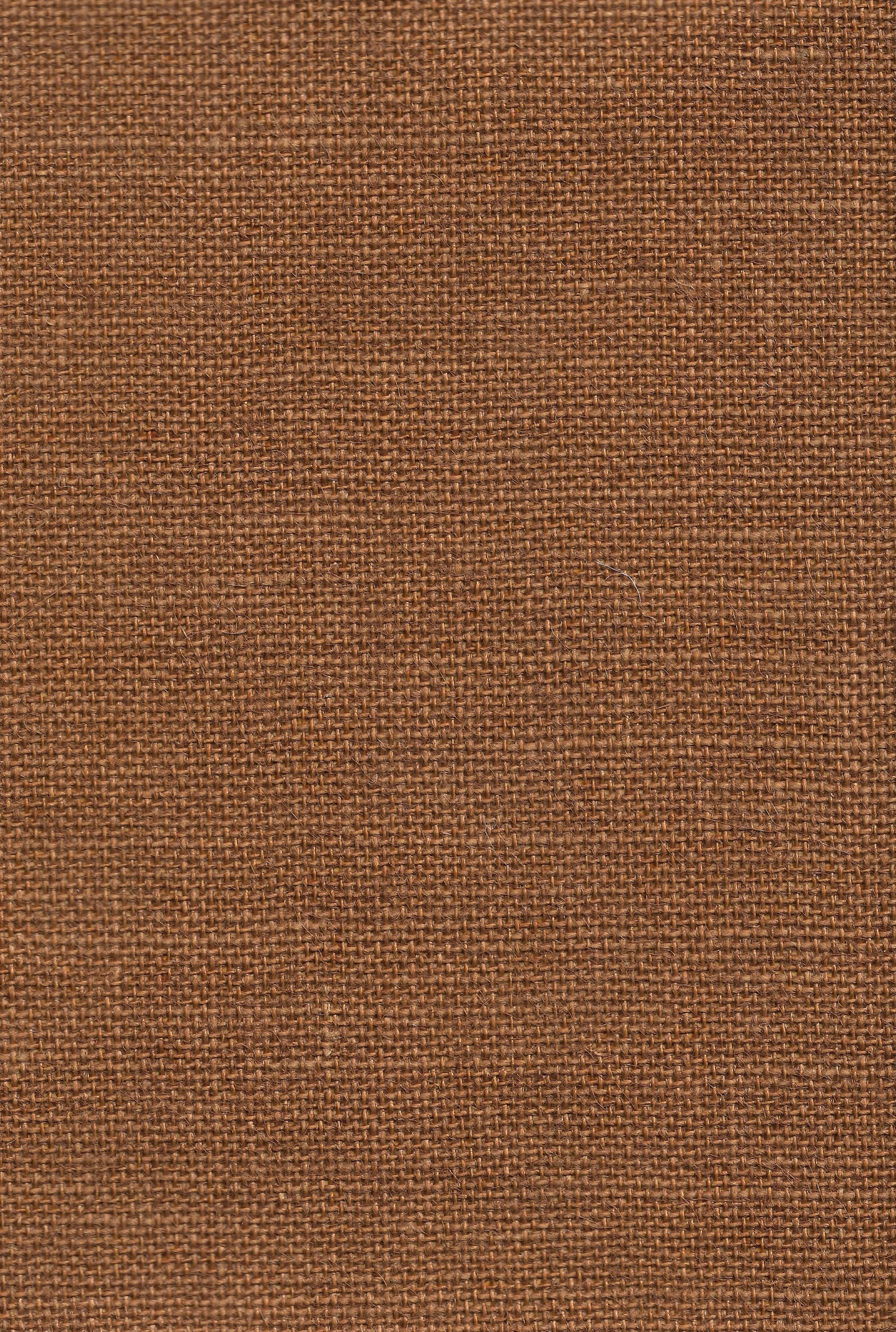Close-up of brown burlap fabric texture, coarse woven jute with warm rustic color.