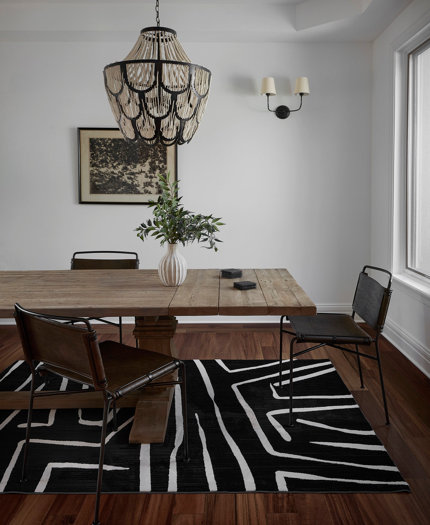 Black-and-white zebra rug, 4' x 6', laid on the floor with a vase of greenery nearby.