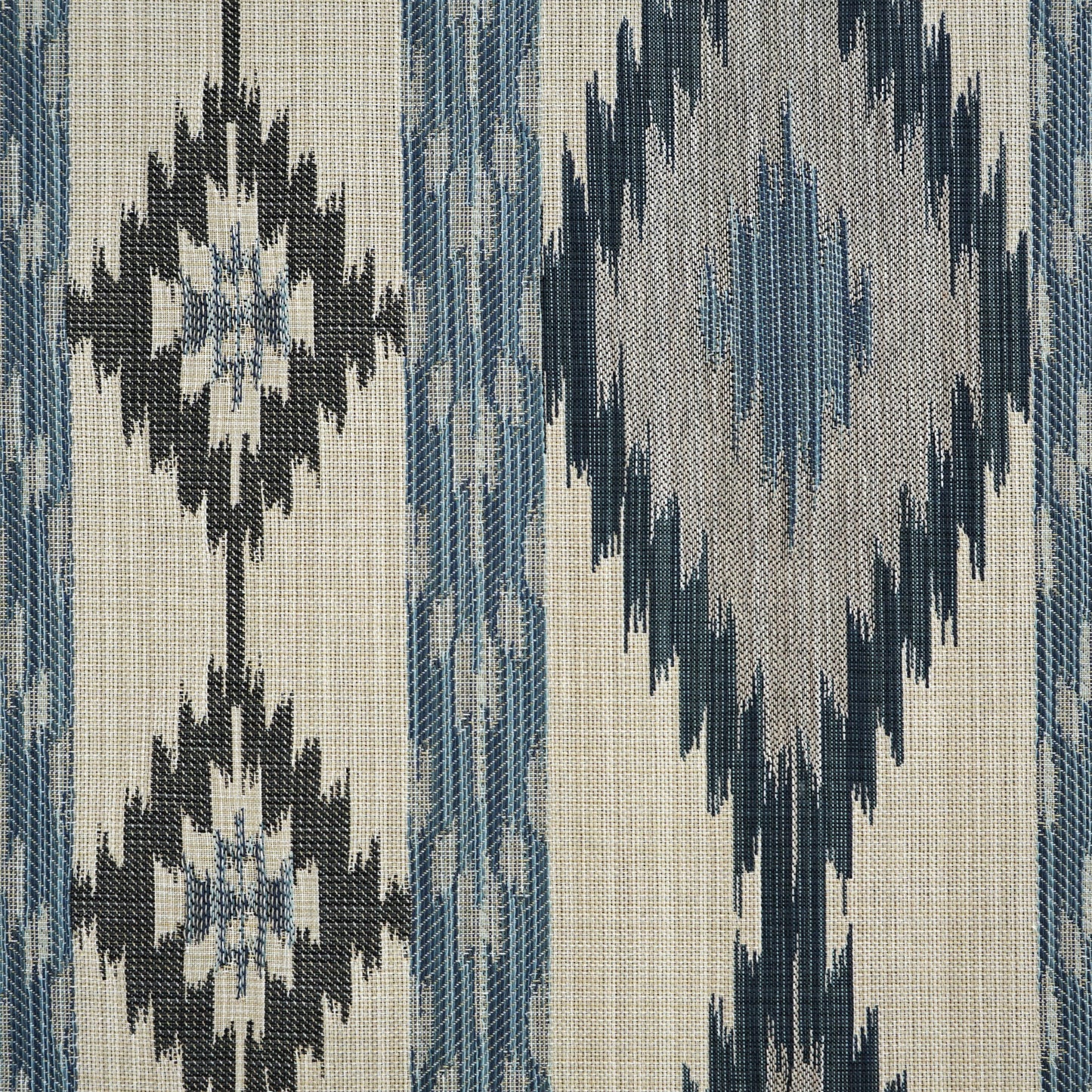 Woven fabric with beige base and blue ikat geometric motifs; rustic decor textile.