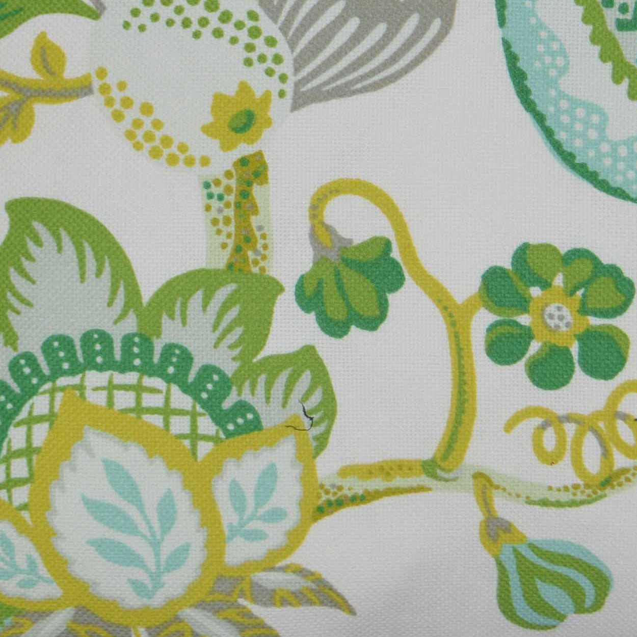 Outdoor lumbar pillow with a botanical print of yellow, green and turquoise leaves, flowers and vines on a light background, 12x24