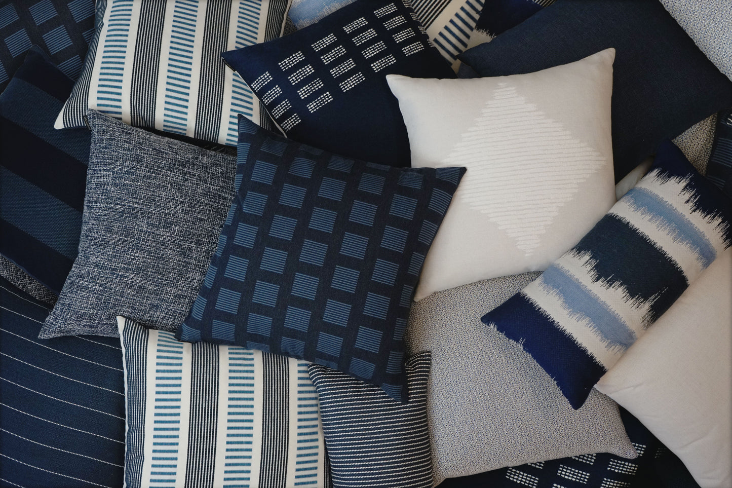 22-inch D.V. KAP HOME Malibu Indigo outdoor pillow featuring classic blue and ivory striped fabric with coastal nautical design. Luxury square accent pillow with Deluxe Angel Hair insert styled for outdoor patios, poolside seating, beach house decor, modern porches, and coastal living room interiors.