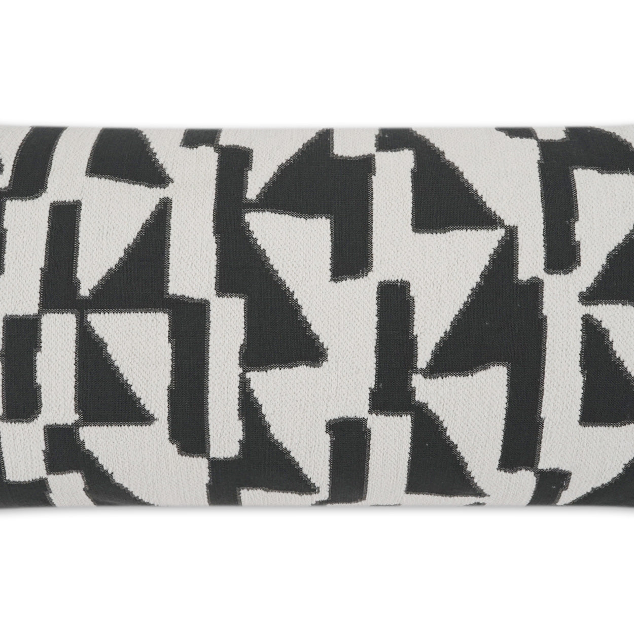Close-up of black geometric triangles on white fabric, bold modern abstract textile pattern.