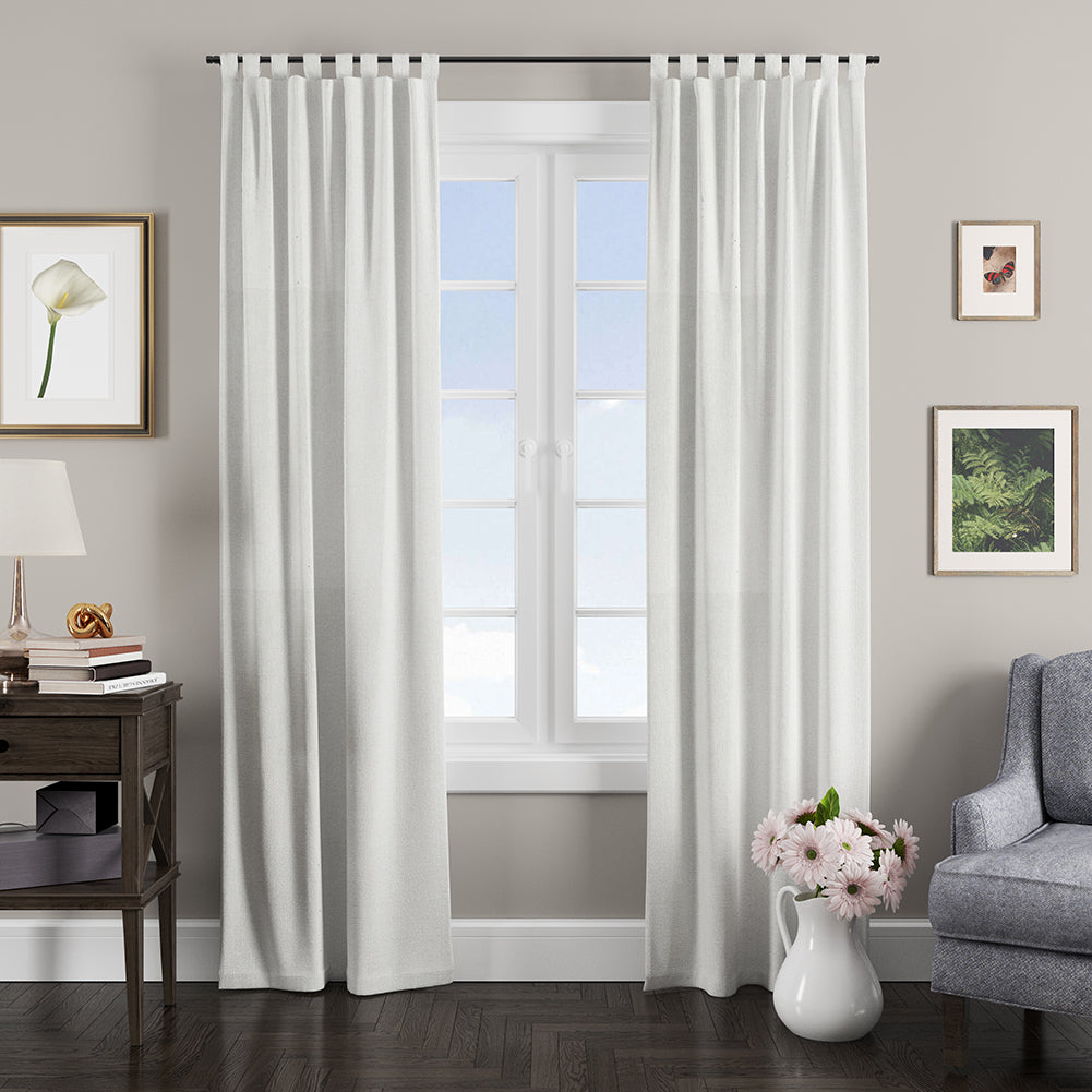 White linen-look curtains in snow solid textured fabric with a grommet top, hung over a window in a gray living room.