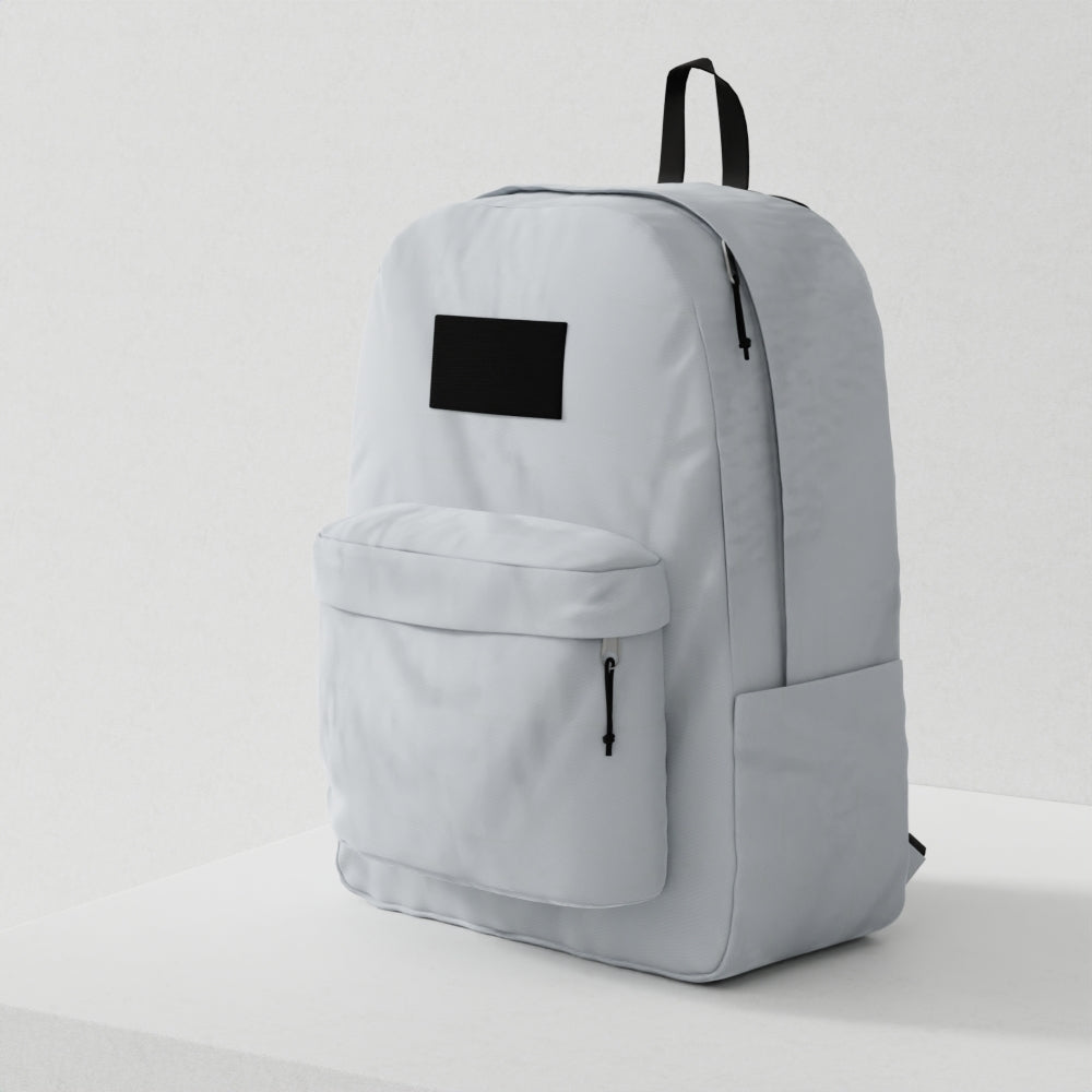 Light grey backpack with black top handle, front zip pocket, rectangular black label, and minimalist city style.