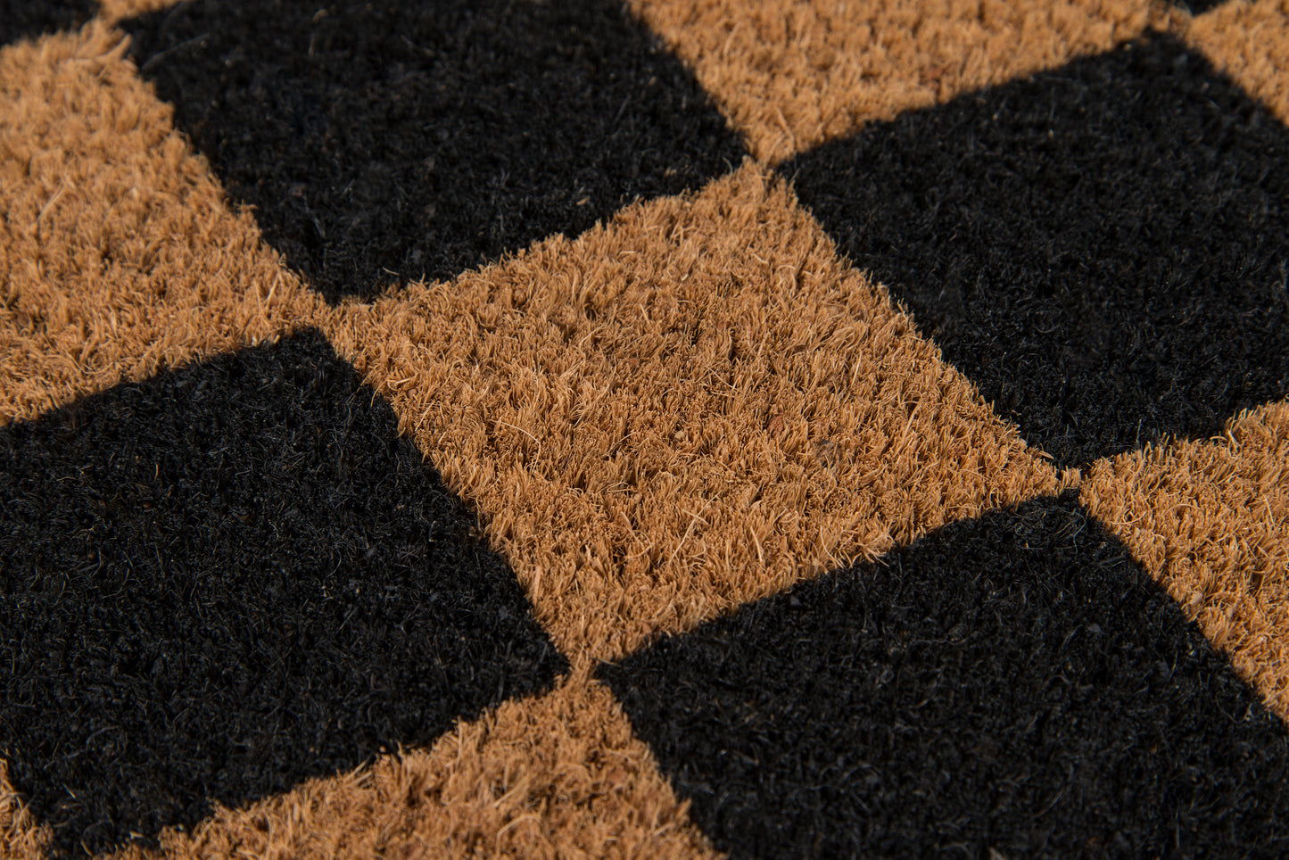 Brown and black checkerboard coir rug with textured pile; square tile pattern for entryway.