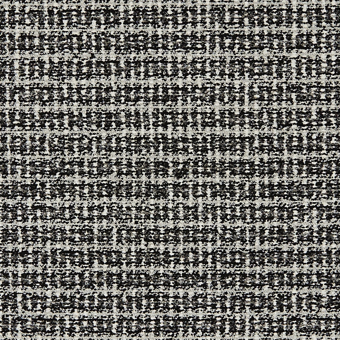 Close-up of black & white boucle jacquard fabric with a speckled gray weave; textured textile.