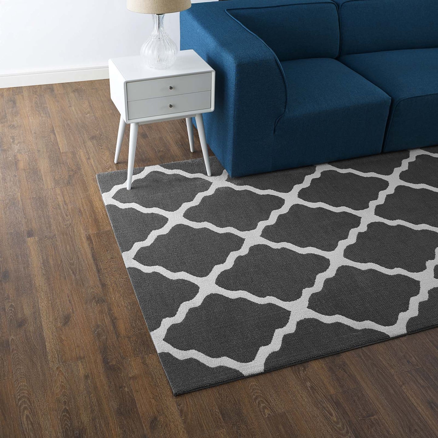 Charcoal and ivory Moroccan trellis area rug, 5x8, on the floor in a living room.
