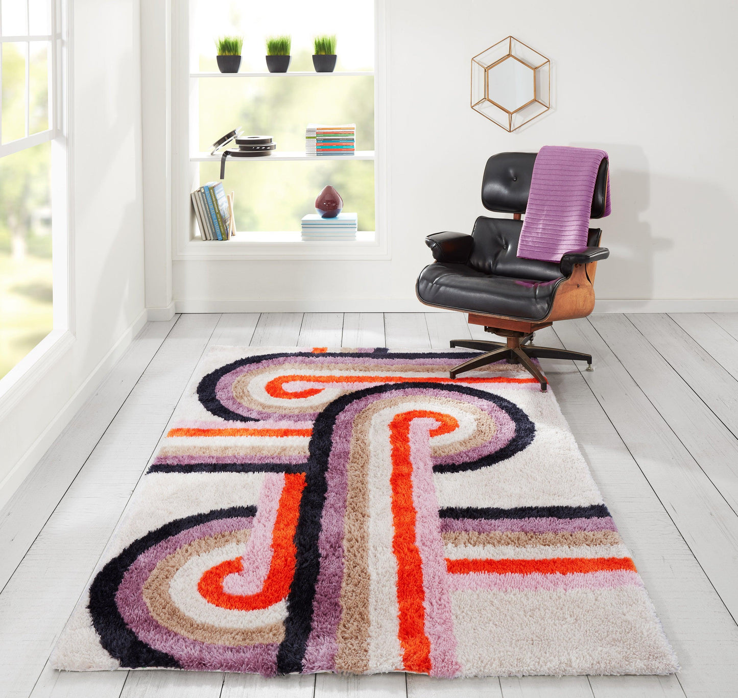 Shaggy geometric retro area rug with swirls in purple, pink, orange and cream; pairs with black leather lounge chair