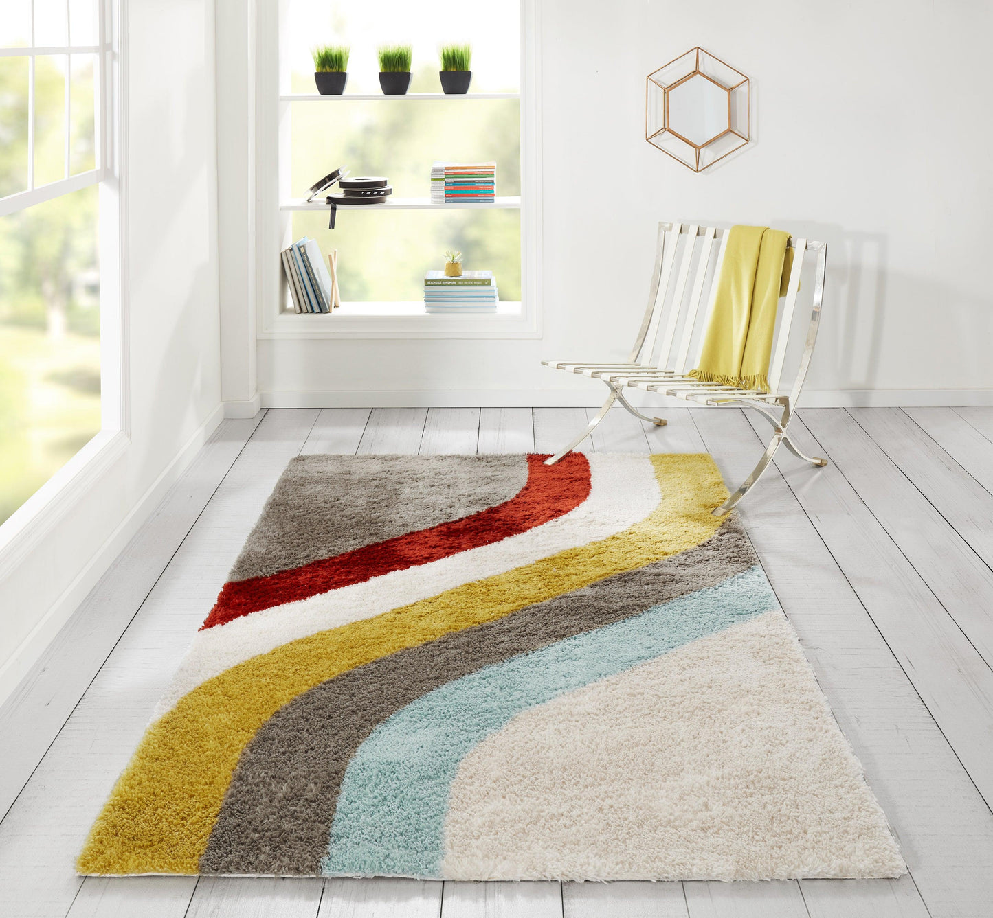 Bright room with a retro shag rug featuring wavy red, yellow, brown, teal and beige stripes beside a white metal chair.