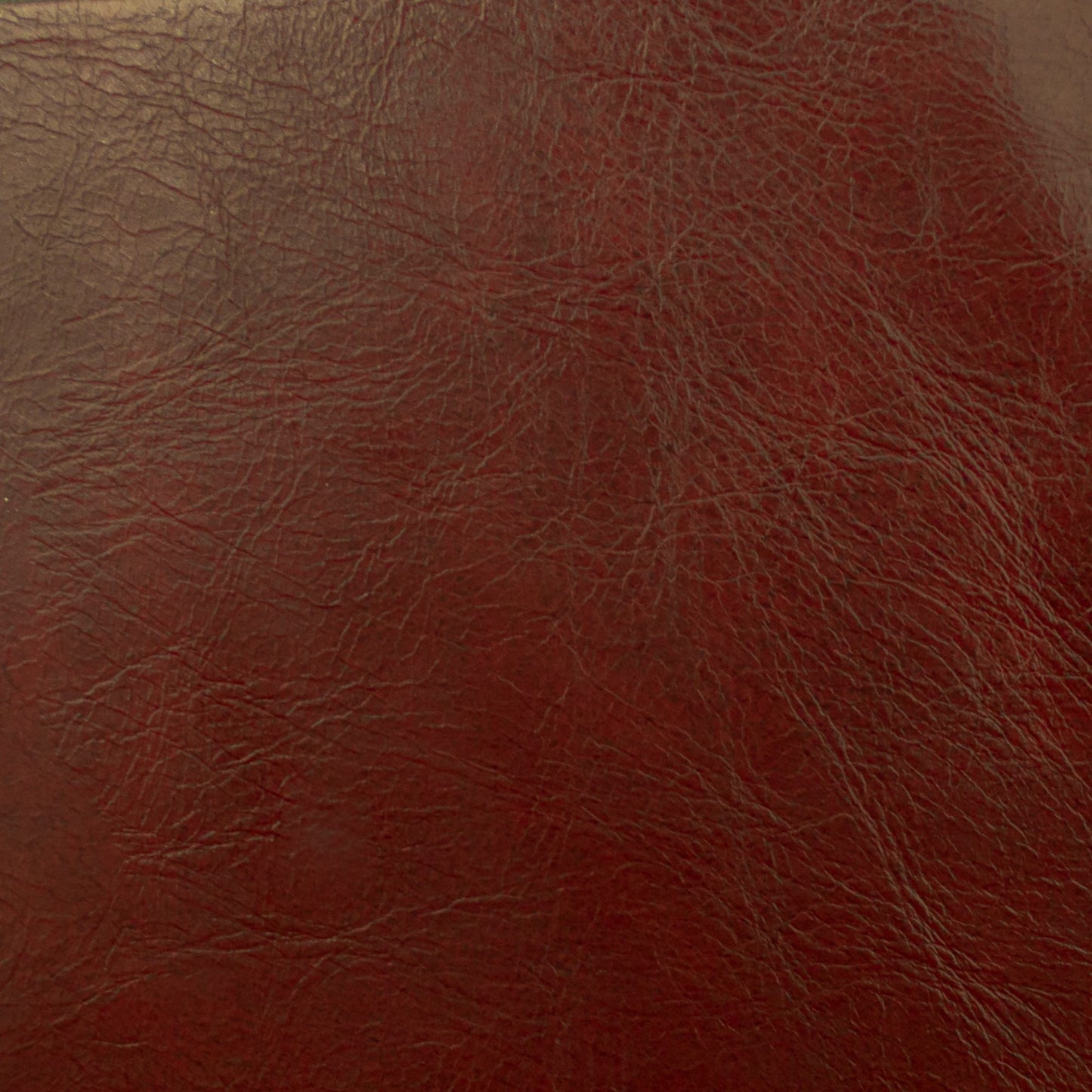 Close-up of red vegan leather texture with subtle grain.