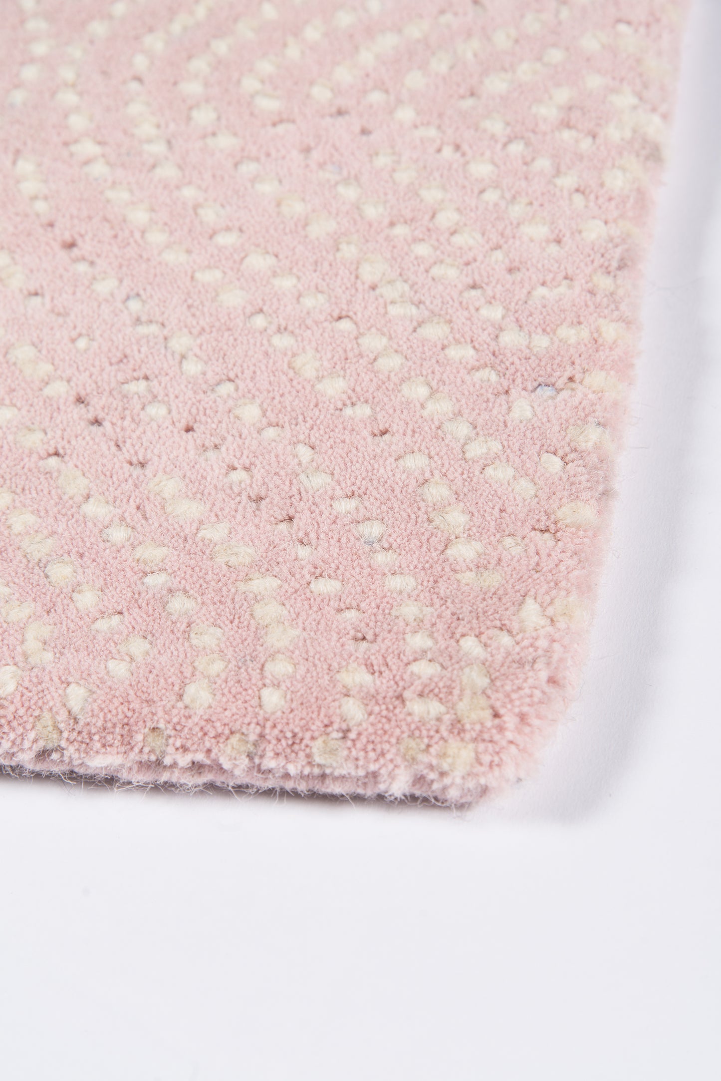 Soft pink plush rug with cream raised dot pattern; tufted microfiber bath mat, rectangular.