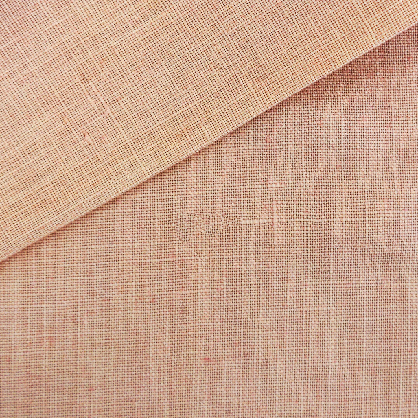 Pink linen fabric with a natural weave, folded corner, rustic texture, suitable for upholstery or crafts.