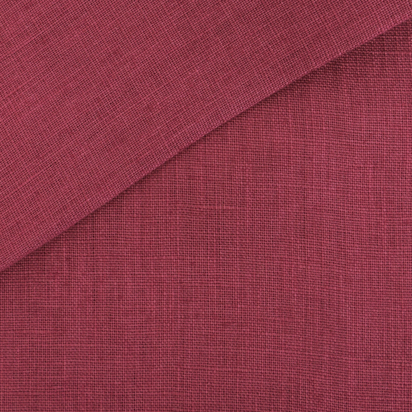 Pink linen-look fabric swatch with a folded diagonal corner and a textured weave.