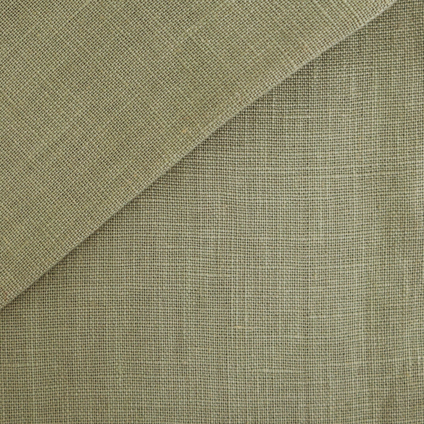 Blue linen fabric close-up with a folded corner, showing a tight woven texture for upholstery.