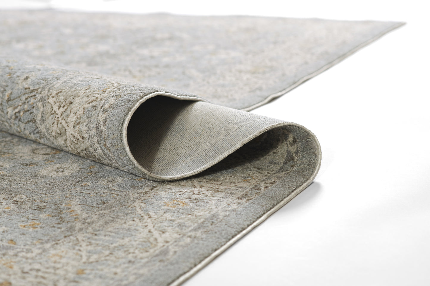 Gray-blue marbled area rug with beige tones, low-pile, rolled corner showing binding, modern distressed pattern.