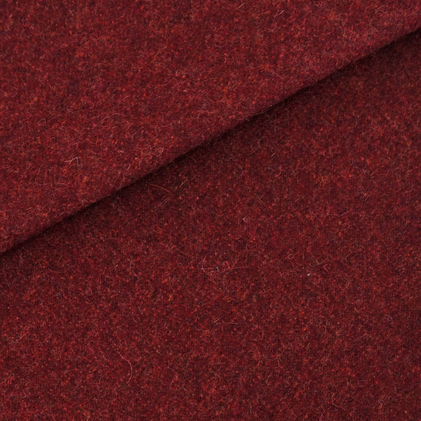 Rich burgundy wool fabric close-up with a diagonal fold; soft flecked texture, ideal for coats.