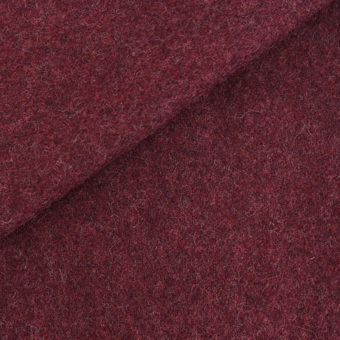 Deep burgundy wool fabric with fuzzy texture and a diagonal fold.
