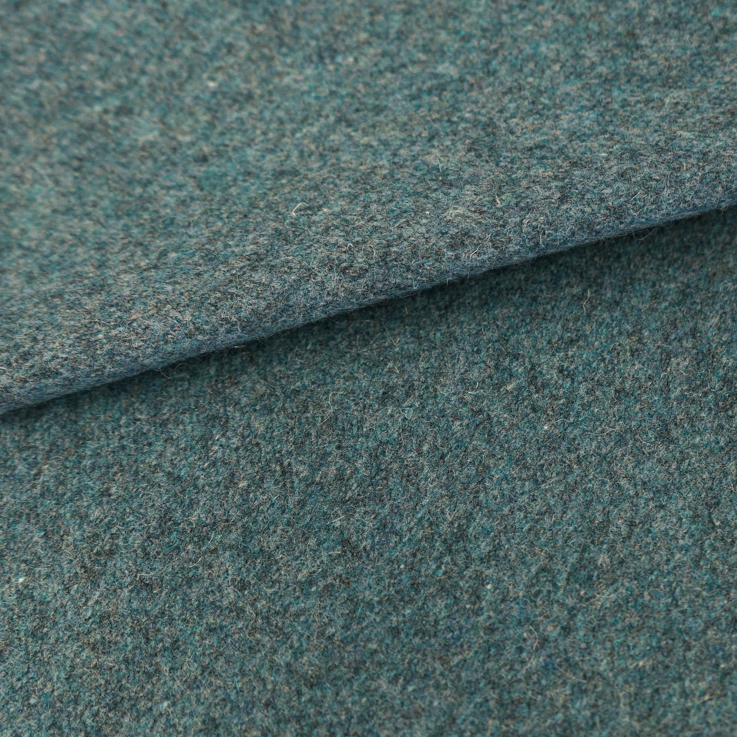 Blue wool fabric with a folded edge; textured material suitable for upholstery or blankets.