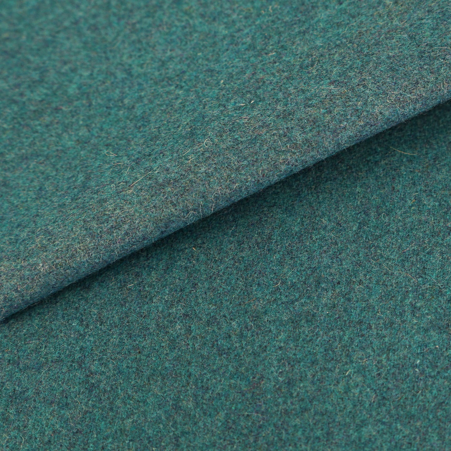 Blue wool fabric close-up with a soft, fuzzy texture and folded edge.